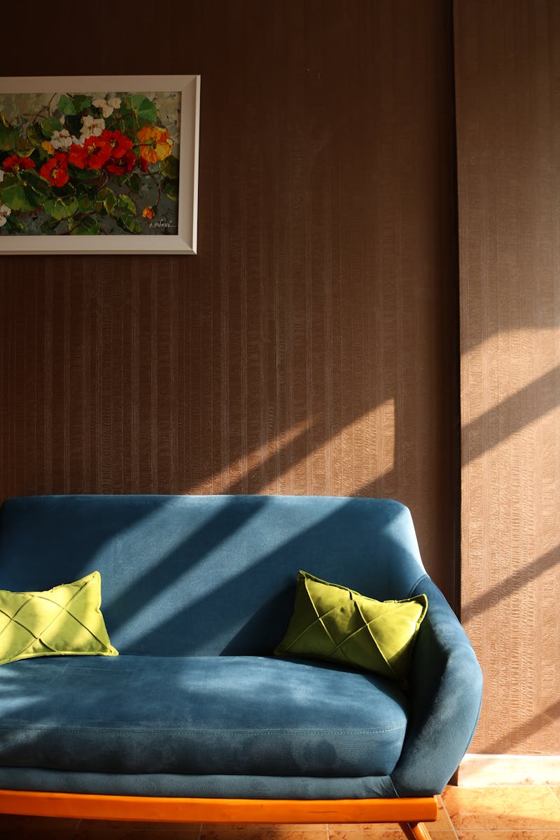 Cozy living room interior featuring a blue sofa, vivid cushions, and wall art.